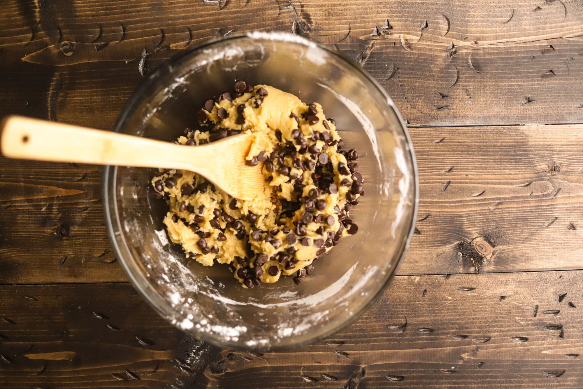 A bowl of chcolate chip cookie dough getting mixed up.