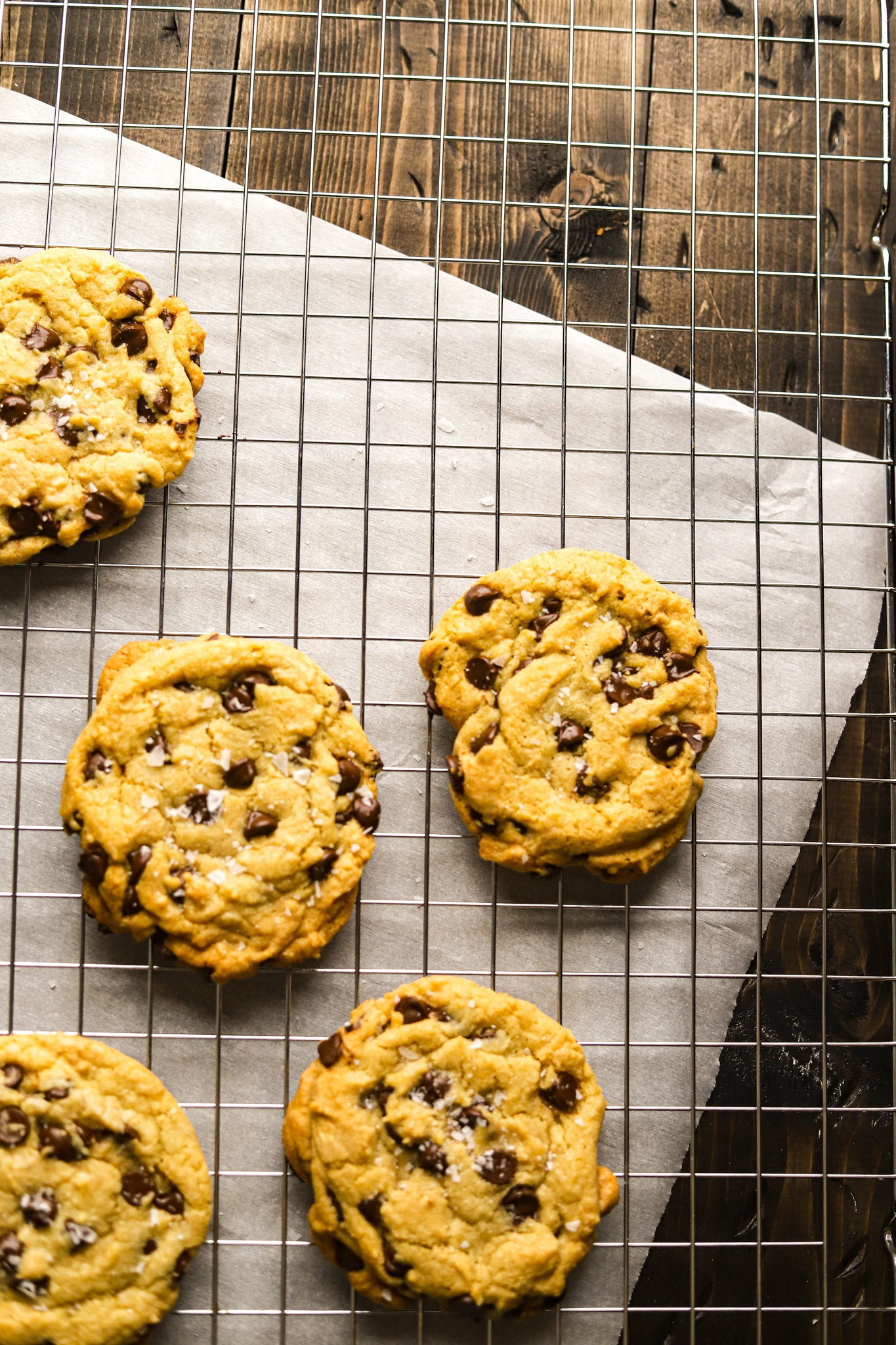 A wire rack of hot chocolate chip cookies out of the oven. 