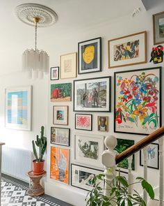 "An elegant gallery wall featuring a variety of framed artworks, each piece illuminated by sleek picture lights and adjustable spotlights, creating a warm and inviting atmosphere in the living room."